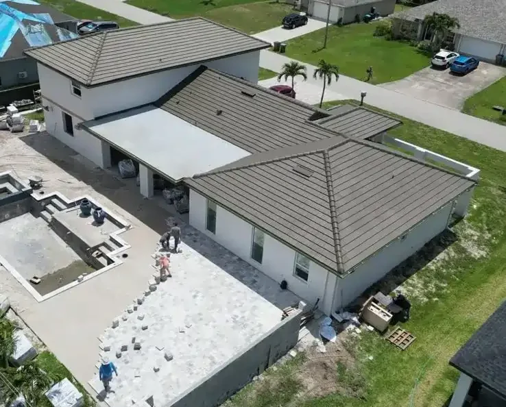 Large pool construction with pavers being installed.