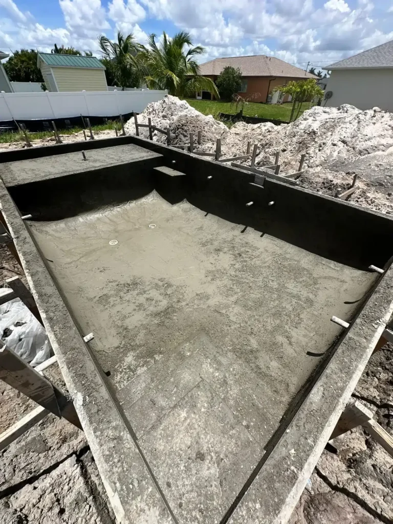 Ongoing construction of a concrete pool with wooden formwork.