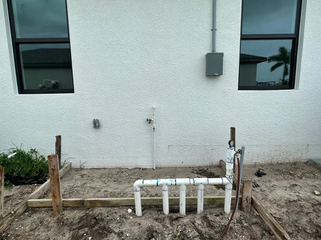 Pool piping valves installed on a wall of a house.