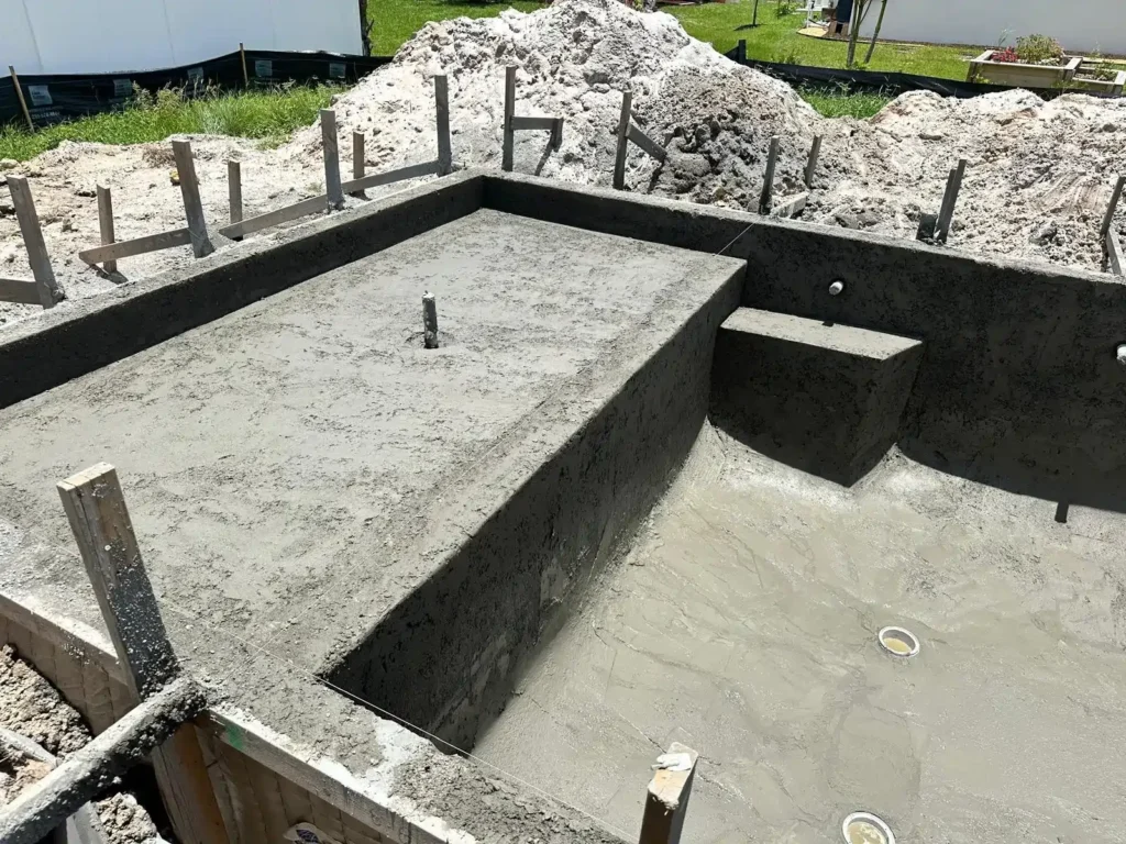 Pool under construction with a sun shelf.