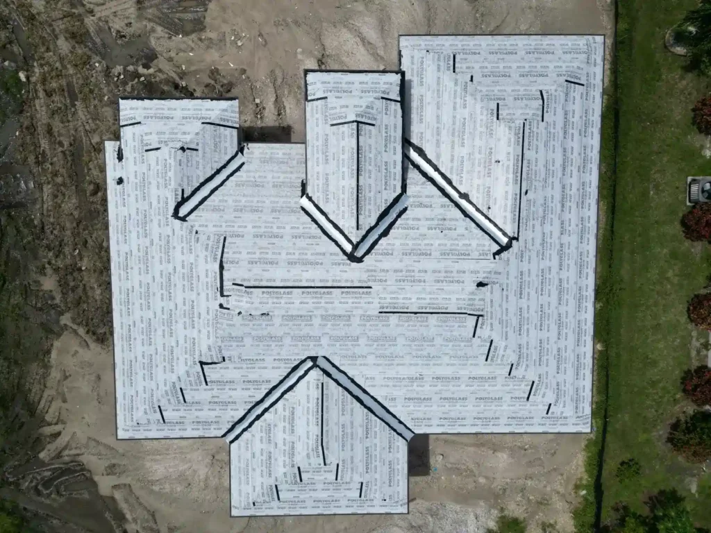 Aerial view of roof underlayment installation on a new home.