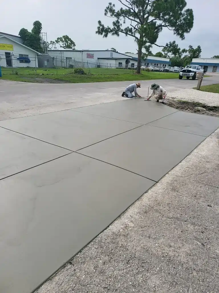 Workers finishing a concrete driveway.