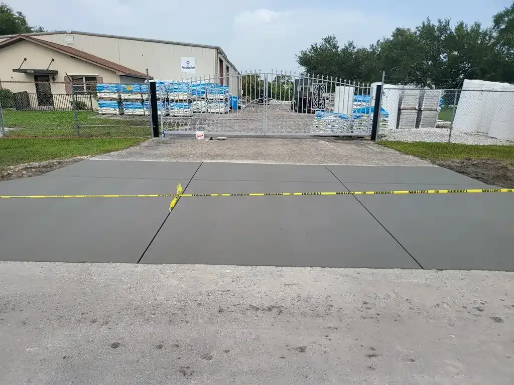 Fresh concrete drying at a driveway entrance.