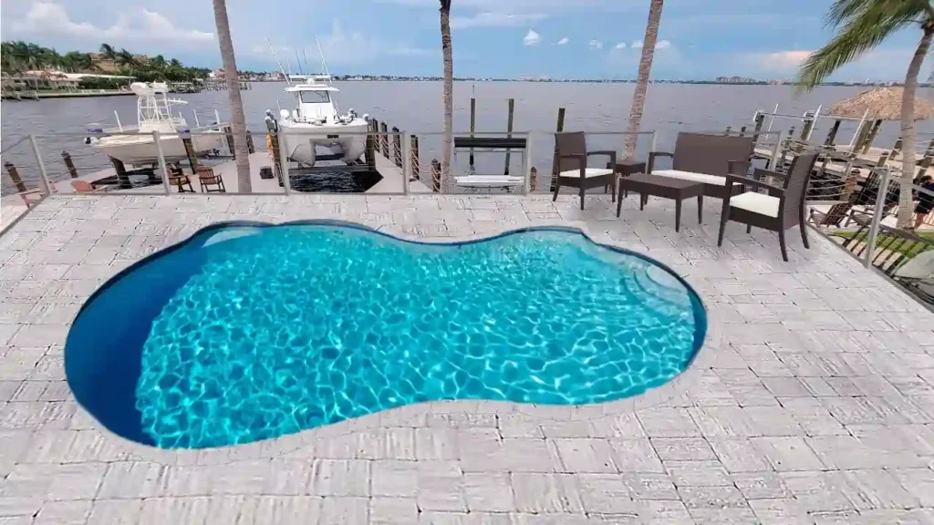 Elevated swimming pool deck facing a waterfront dock.