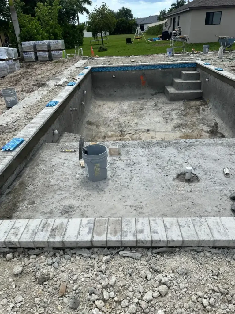 Installation of coping around the edge of a swimming pool.