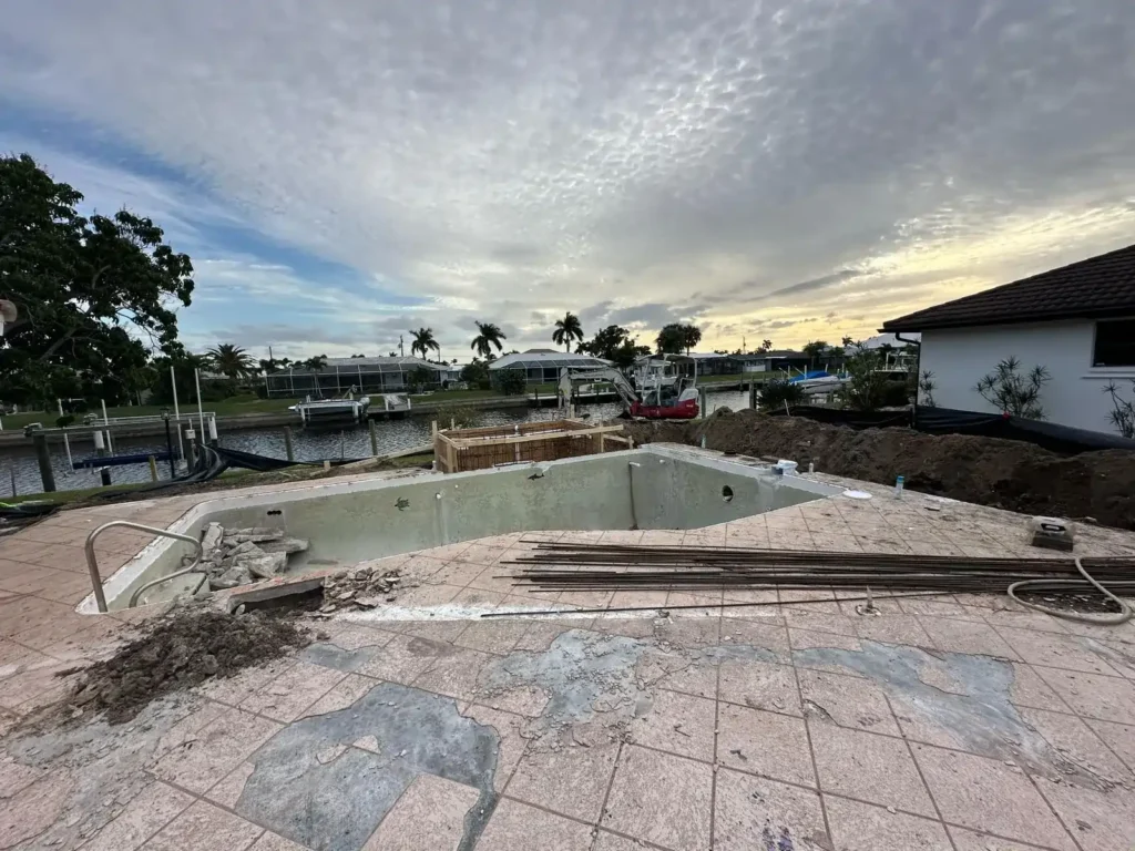 Initial stage of pool renovation with old tiles and pool structure.