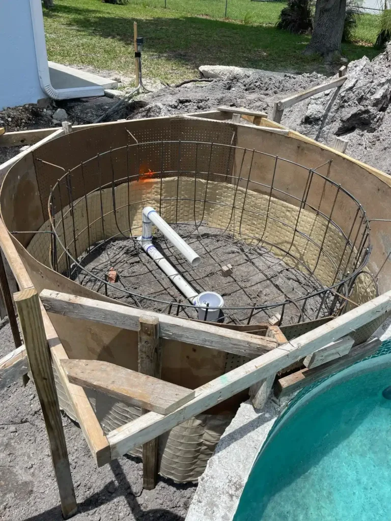 Early stage of pool renovation with circular concrete structure and rebar.