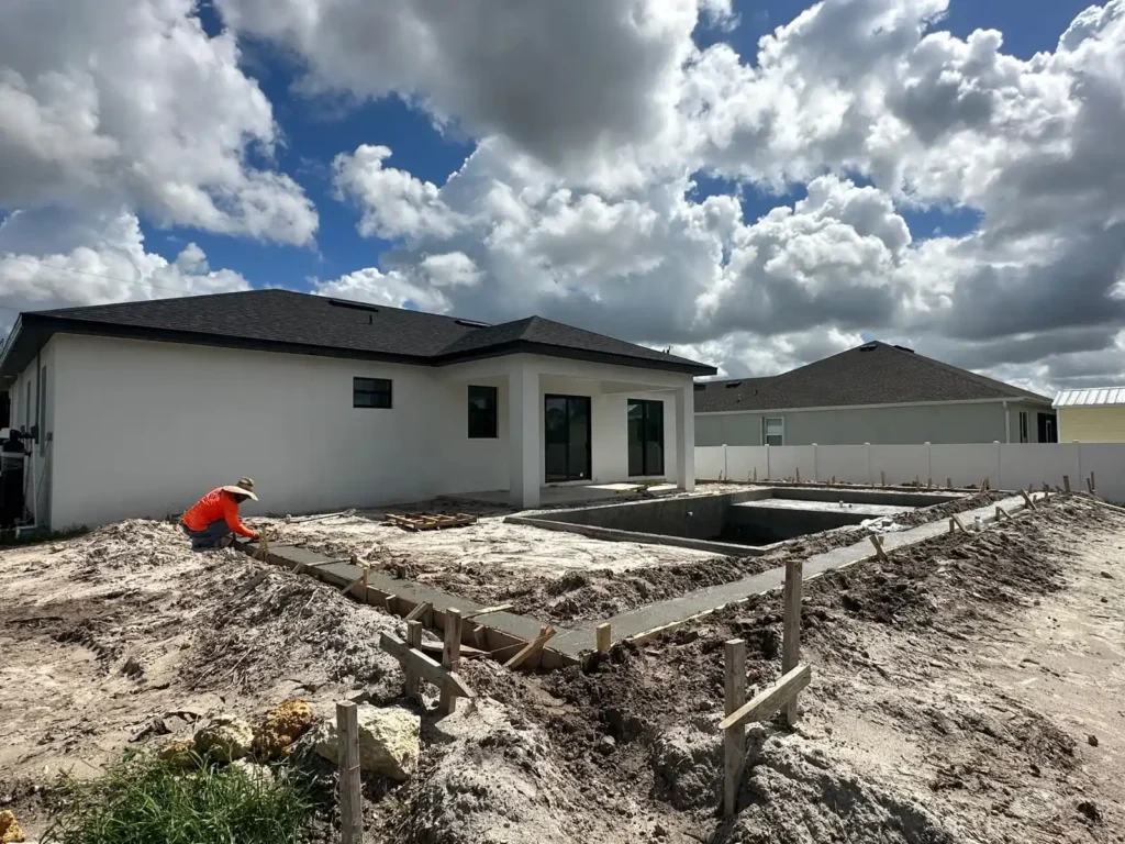 Worker setting up concrete foundation during pool renovation.