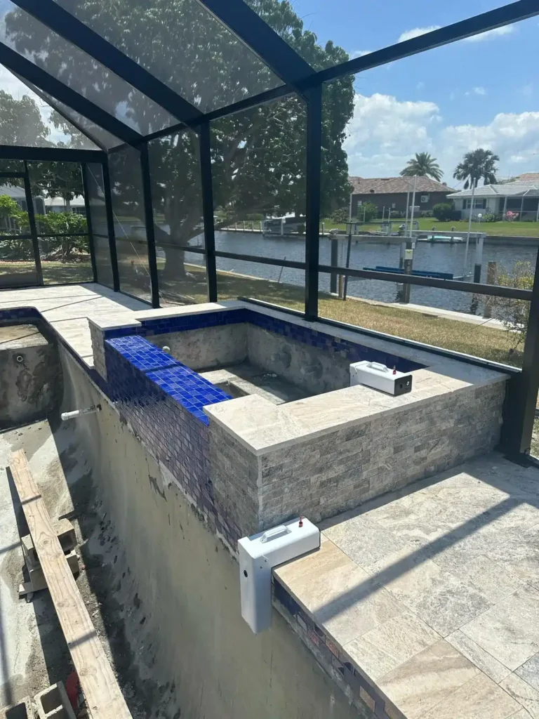 Close-up of pool renovation with new tile installation and spa area.