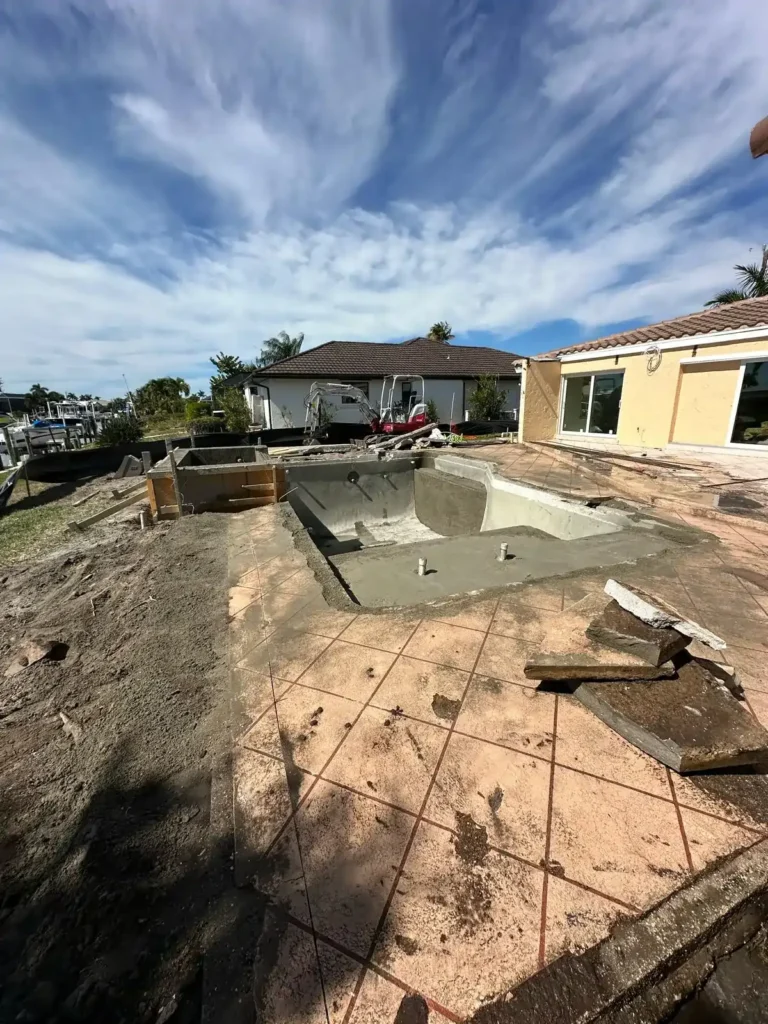 Pool renovation progress with concrete structure and new design elements.