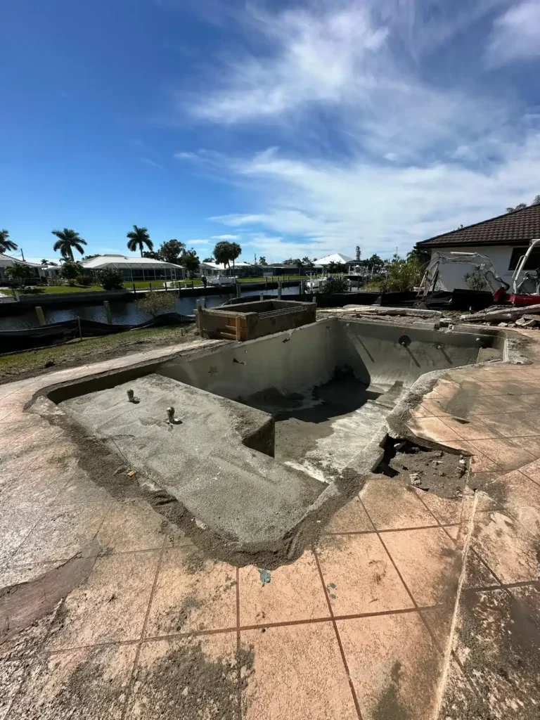 Early stage of pool renovation with exposed concrete and rebar.