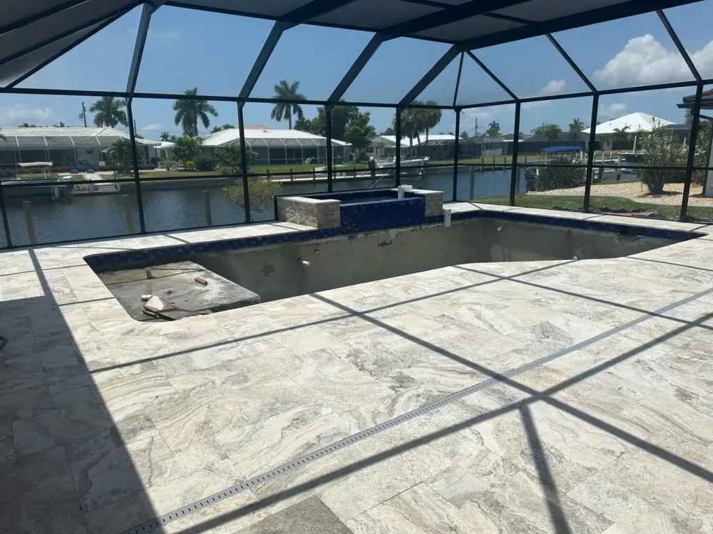 Pool renovation progress with new tile flooring and pool structure.