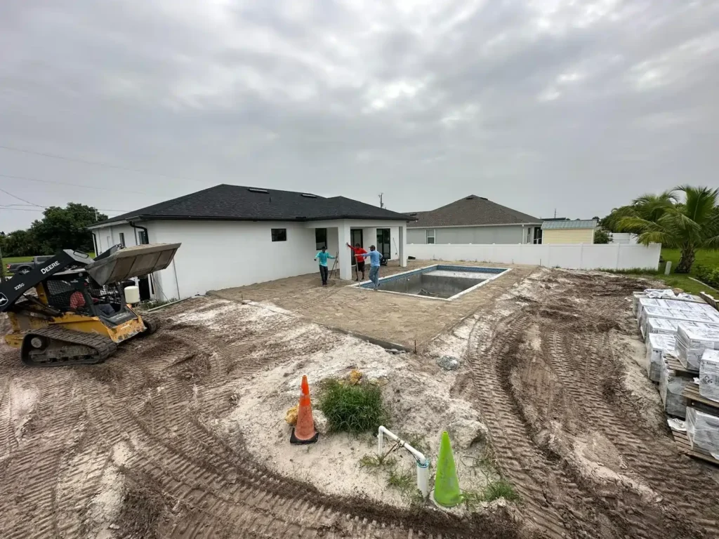 Workers preparing a backyard for paver installation.