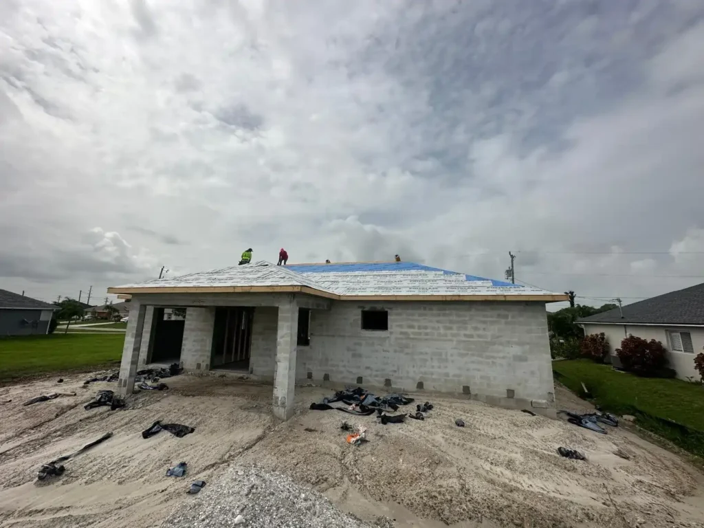 Workers installing roof underlayment.