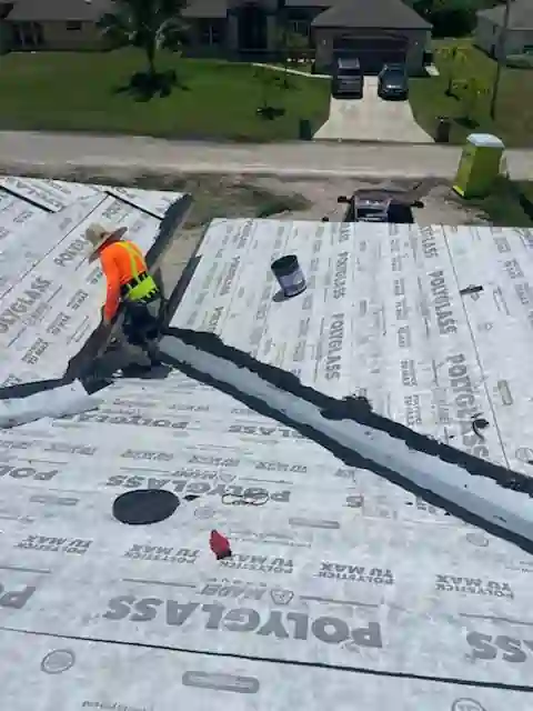 Roofing crew putting final touches on roof underlayment installation.