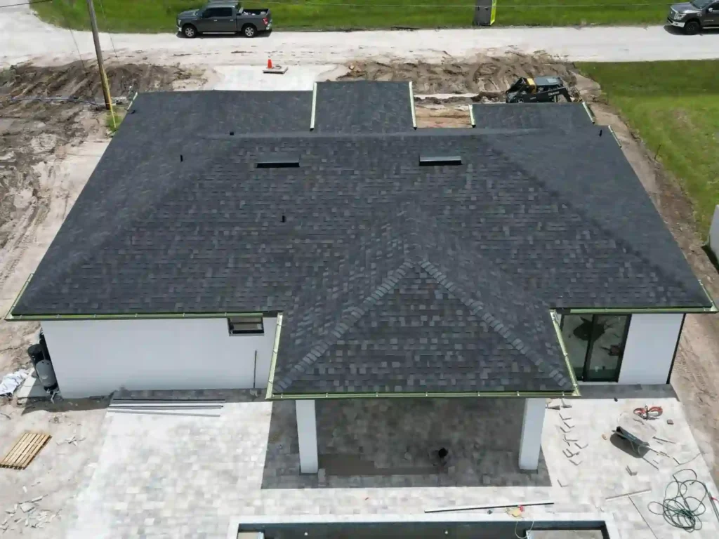 Completed shingles and gutters on the roof of a new home, aerial view.