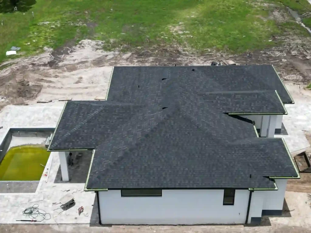 Side view of a new home with installed shingles and gutters.