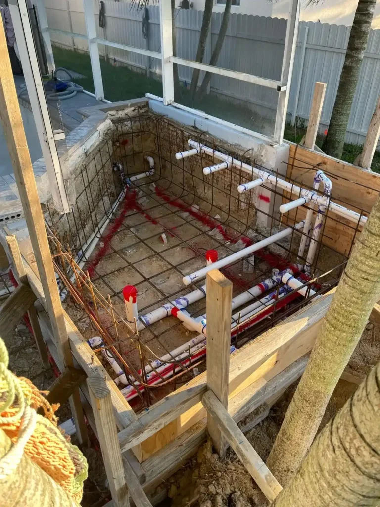 Early stage of spa renovation with visible piping and rebar framework.