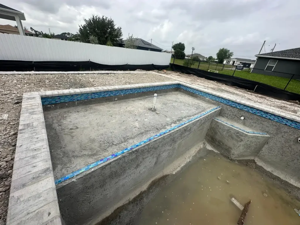 Sun shelf with tile strips in a pool under construction.