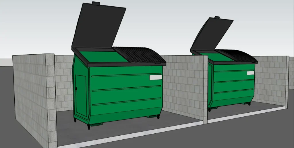 Two green dumpsters inside separate concrete block enclosures with open lids.