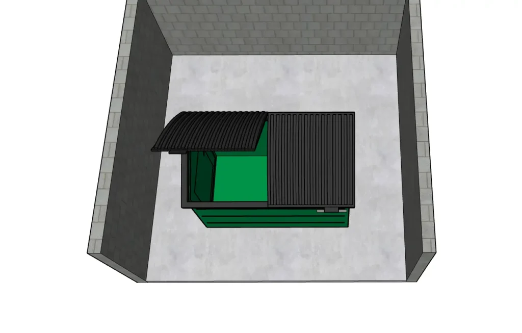 Top-down view of a green dumpster inside a three-sided concrete block enclosure.