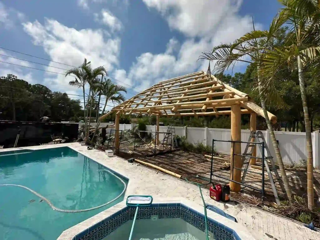 Tiki hut next to a pool and tub, ideal for relaxation.