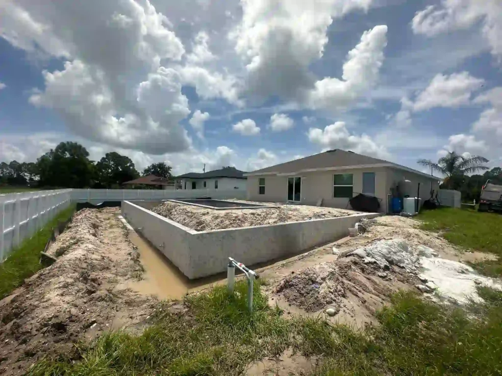 Pool construction site with deck filled before compaction, viewed from a different angle.